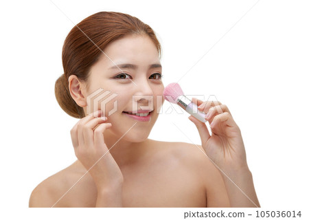 clean-skinned female model holding a makeup brush against a white background clean-skinned female model holding a makeup brush against a white background 105036014
