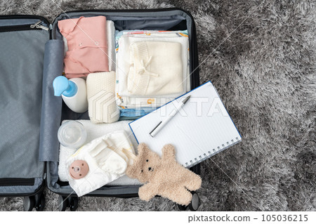 Open bag for maternity hospital. Suitcase of baby clothes prepared for newborn birth. Concept of getting ready for the maternity hospital, packing baby stuff Open bag for maternity hospital. Suitcase of baby clothes prepared for newborn birth. Concept of getting ready for the maternity hospital, packing baby stuff 105036215