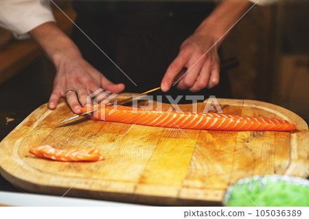 Chef cutting salmon fillet Chef cutting salmon fillet 105036389
