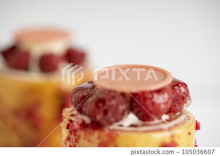 A delicious dessert of raspberry pudding topped with luscious cream and a sweet drizzle A delicious dessert of raspberry pudding topped with luscious cream and a sweet drizzle 105036607