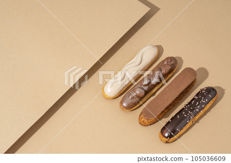 A set of delicious glazed donuts in a variety of flavors, arranged on a cardboard paper in an inviting display A set of delicious glazed donuts in a variety of flavors, arranged on a cardboard paper in an inviting display 105036609