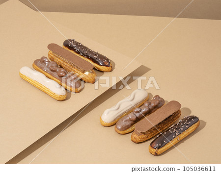 A set of delicious glazed donuts in a variety of flavors, arranged on a cardboard paper in an inviting display 105036611