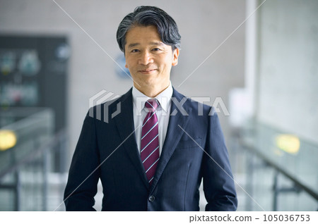 站立在辦公室走廊的中間商人 站立在辦公室走廊的中間商人 105036753