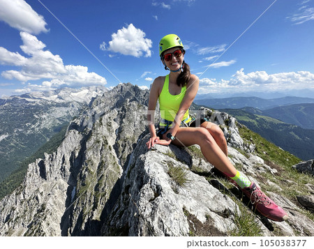 Female climber on a via ferrata - climbing on a rock in Austria Alps Female climber on a via ferrata - climbing on a rock in Austria Alps 105038377