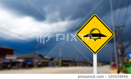Graphic of UFO on yellow sign on blurred background to warn traffic to aware of UFO 105039048