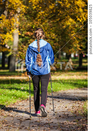 Nordic walking adventure and exercising concept - woman hiking withnordic walking poles in park 105039825