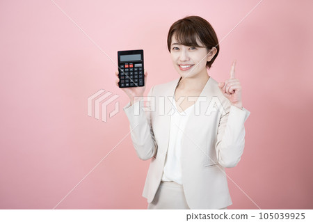 一個微笑的女人拿著一個粉紅色背景的黑色計算器 105039925