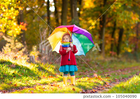Kid with umbrella playing in autumn rain. Kid with umbrella playing in autumn rain. 105040090