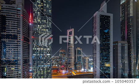 Panorama showing aerial view of Dubai International Financial District with many skyscrapers night timelapse. Panorama showing aerial view of Dubai International Financial District with many skyscrapers night timelapse. 105040357