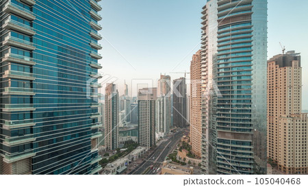 View of the Dubai Marina and JBR area and the famous Ferris Wheel aerial night to day timelapse 105040468