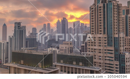 Dubai skyscrapers with golden sunset over business bay district timelapse. Dubai skyscrapers with golden sunset over business bay district timelapse. 105040594