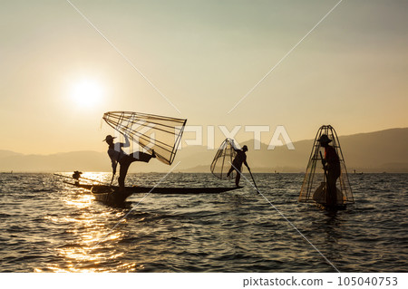 Myanmar travel attraction landmark - three traditional Burmese fishermen at Inle lake, Myanmar famous for their distinctive one legged rowing style Myanmar travel attraction landmark - three traditional Burmese fishermen at Inle lake, Myanmar famous for their distinctive one legged rowing style 105040753