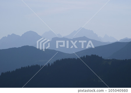 Blue mountain ranges in the morning light seen from Vorder Walig, Switzerland. 105040980