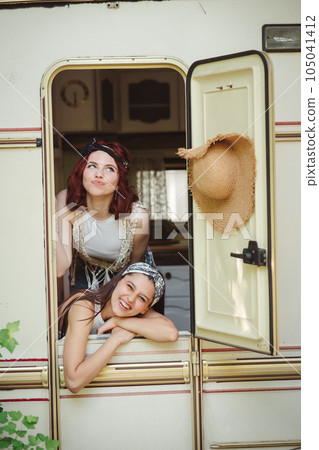Happy hippie friends are having a good time together in a camper trailer. Holiday, vacation, trip concept. 105041412