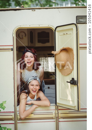 Happy hippie friends are having a good time together in camper trailer. Holiday, vacation, trip concept. Happy hippie friends are having a good time together in camper trailer. Holiday, vacation, trip concept. 105041416