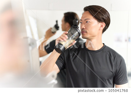 A man wearing sportswear drinking a drink 105041768