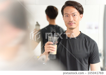 A man wearing sportswear holding a drink 105041769
