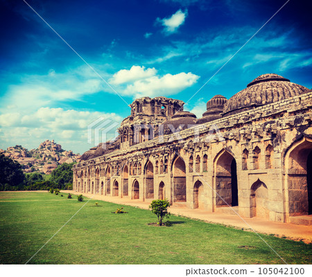 Vintage retro effect filtered hipster style travel image of Ancient ruins of Elephant Stables, Royal Centre. Hampi, Karnataka, India. Stitched panorama 105042100