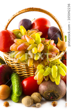 Fruits and vegetables in a basket isolated on a white . Vertical photo. 105042236