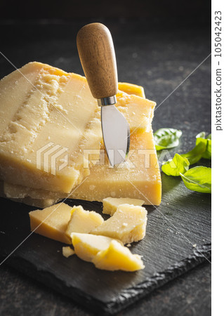 Tasty parmesan cheese on cutting board. Tasty parmesan cheese on cutting board. 105042423