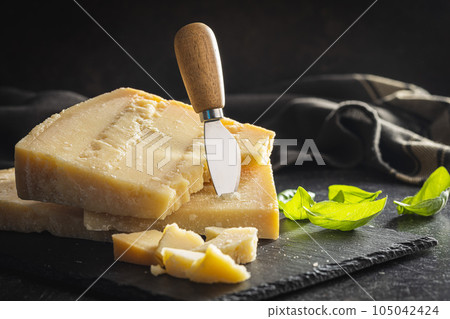 Tasty parmesan cheese on cutting board. 105042424