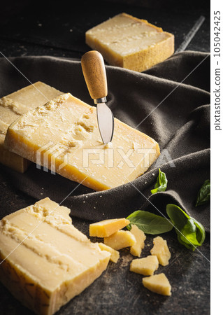Tasty parmesan cheese on black table. 105042425
