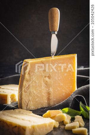 Tasty parmesan cheese on black table. 105042426