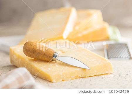 Tasty parmesan cheese on kitchen table. 105042439