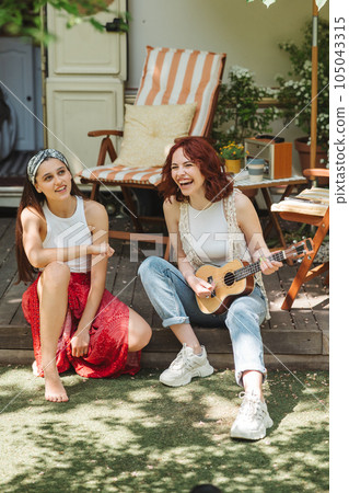 Happy hippie friends are having a good time together with guitar in camper trailer. Holiday, vacation, trip concept. Happy hippie friends are having a good time together with guitar in camper trailer. Holiday, vacation, trip concept. 105043315
