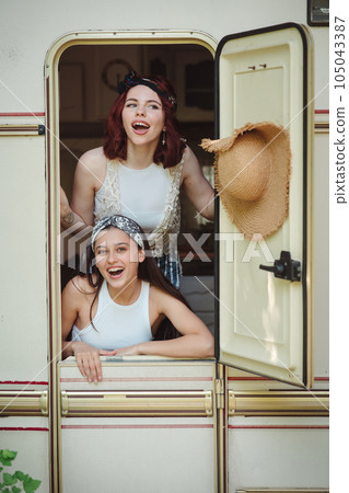 Happy hippie friends are having a good time together in a camper trailer. Holiday, vacation, trip concept. Happy hippie friends are having a good time together in a camper trailer. Holiday, vacation, trip concept. 105043387
