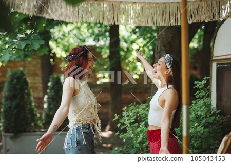 Happy hippie friends are having a good time together in camper trailer. Holiday, vacation, trip concept. 105043453