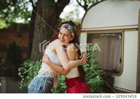 Happy hippie friends are embracing and having a good time together in camper trailer. Holiday, vacation, trip concept. Happy hippie friends are embracing and having a good time together in camper trailer. Holiday, vacation, trip concept. 105043458