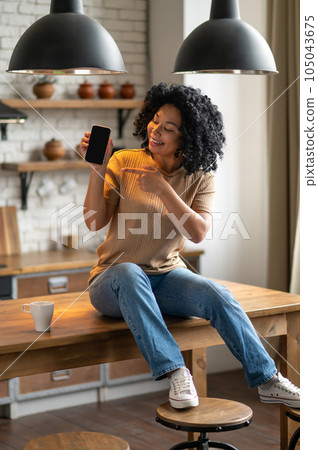 Cute woman with a phone in hands looking excited 105043675