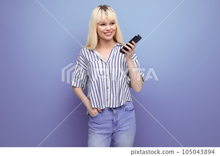 smiling positive blond young woman in a striped shirt chatting on the phone on a studio background smiling positive blond young woman in a striped shirt chatting on the phone on a studio background 105043894