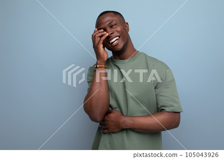 young positive friendly african guy with a short haircut dressed in a basic t-shirt against the 105043926