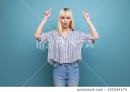 pretty european 20s woman in striped shirt showing hand up on studio background pretty european 20s woman in striped shirt showing hand up on studio background 105044374