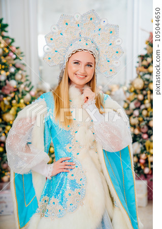 portrait of Snow Maiden in blue costume with kokoshnik. room with christmas tree 105044650