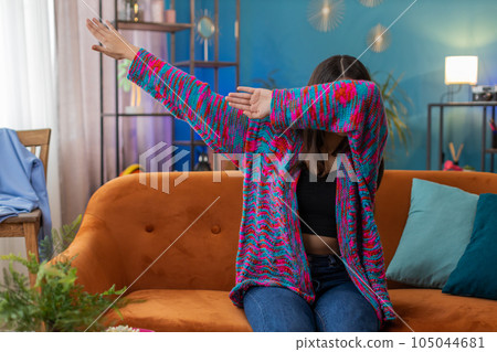 Woman girl having fun dancing and moving to rhythm, dabbing raising hands, making dub dance gesture 105044681