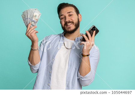 Lebanese man use smartphone rejoicing win, receiving money dollar cash, success lottery jackpot luck 105044697