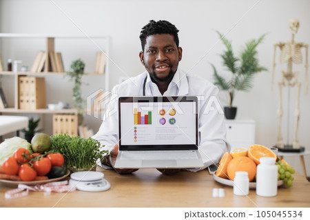 Nutrition specialist posing on camera with portable laptop 105045534