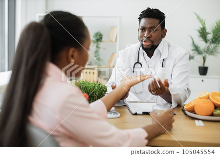 African american doctor giving medicine to patient in clinic African american doctor giving medicine to patient in clinic 105045554