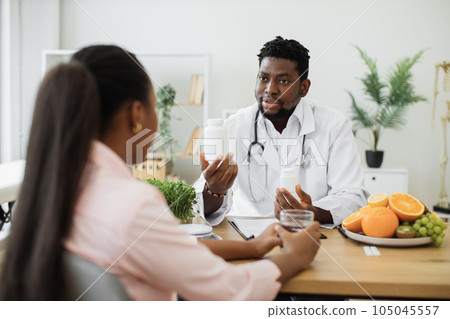 Expert in nutrition holding medicine bottles in office Expert in nutrition holding medicine bottles in office 105045557
