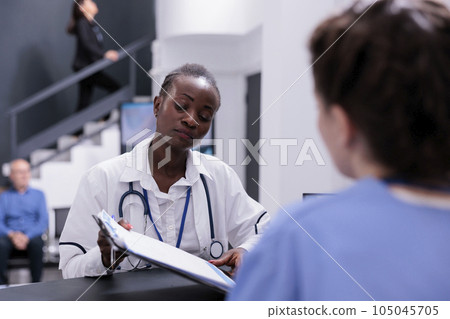 Specialist medic giving medical expertise to assistant discussing patient symptoms working together at medication treatment in hospital waiting room. Health care service and concept 105045705