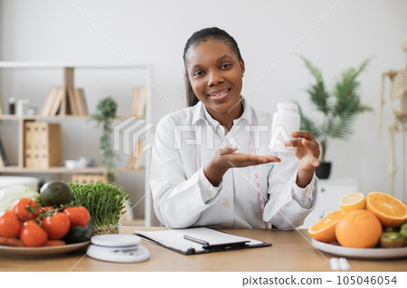 Dietitian offering supplements during working day in clinic Dietitian offering supplements during working day in clinic 105046054