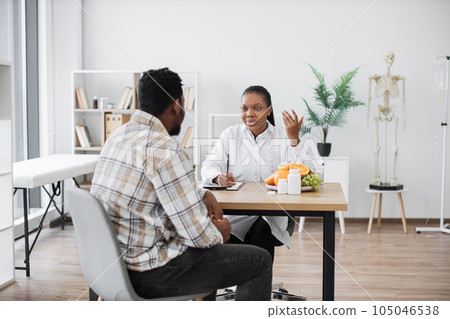 Expert in nutrition talking to man in consulting room 105046538