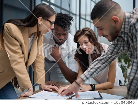 Group of young business people working together while standing in creative office Group of young business people working together while standing in creative office 105046846