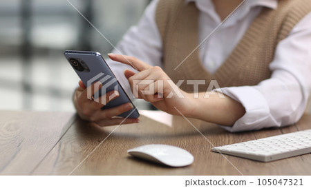 young woman in modern office browsing smartphone young woman in modern office browsing smartphone 105047321