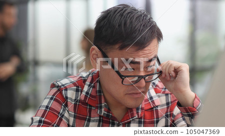 Modern office businessman in casual clothes working on a computer. Modern office businessman in casual clothes working on a computer. 105047369