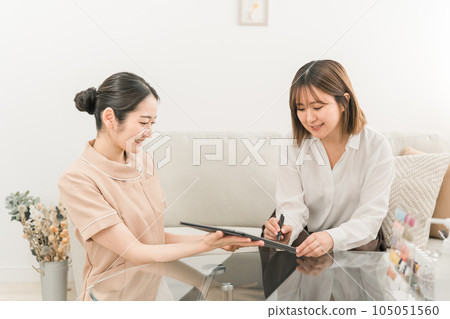 日本女性諮詢美容院的顧問人員,以電子方式在平板電腦上簽署合同 日本女性諮詢美容院的顧問人員,以電子方式在平板電腦上簽署合同 105051560
