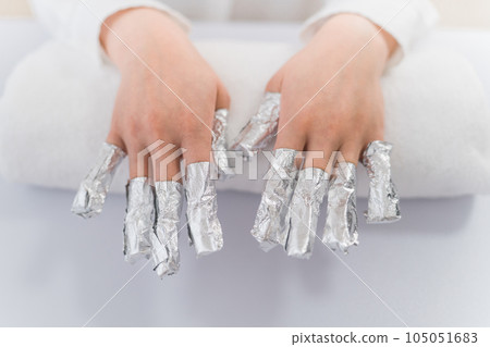 美甲師和亞洲婦女在美甲沙龍用丙酮去除指甲 105051683